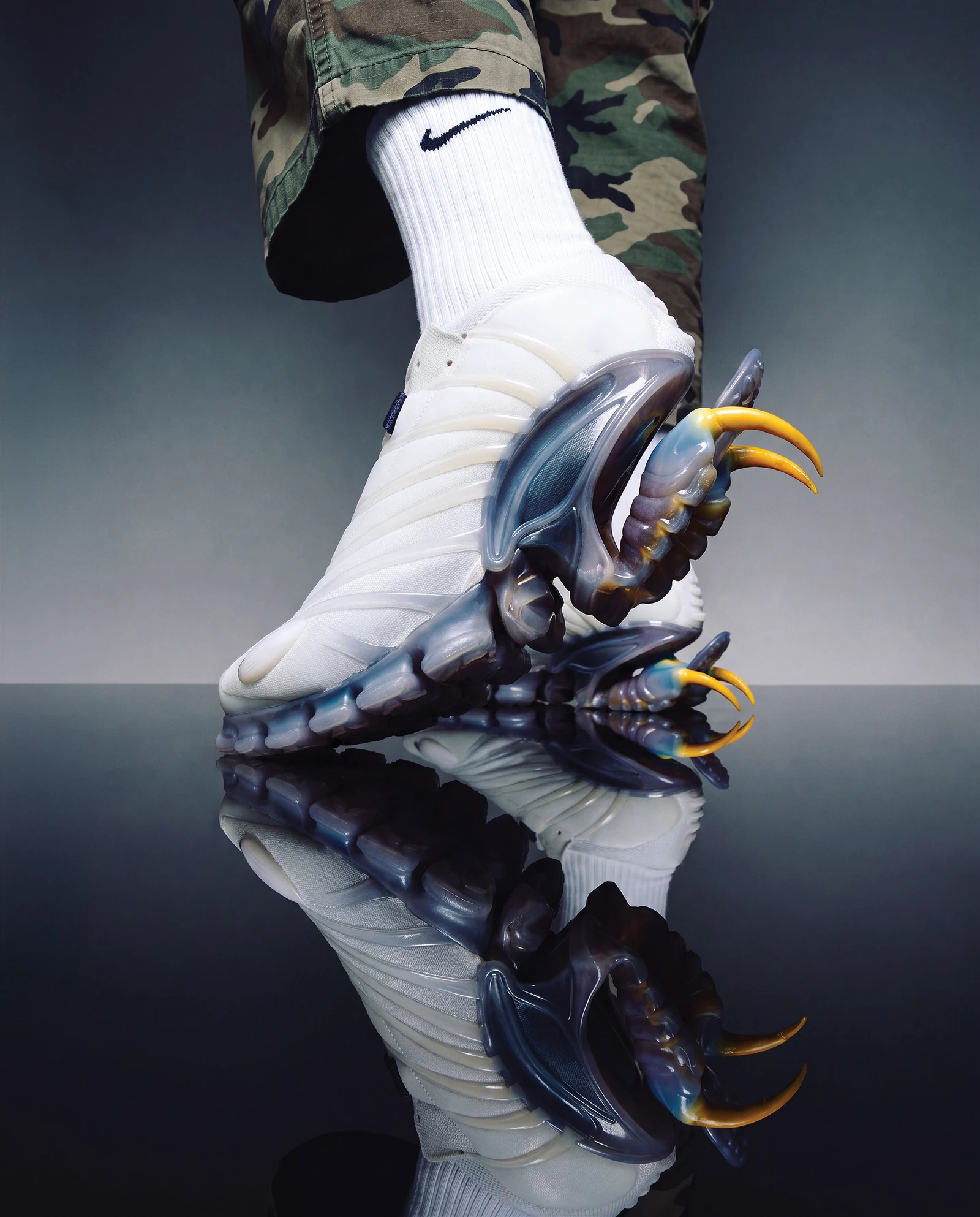 White claw-cushion footwear concept on a reflective studio floor