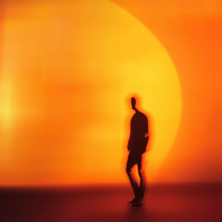 AMPC brand imagery showing a silhouetted person standing in an orange halo of light