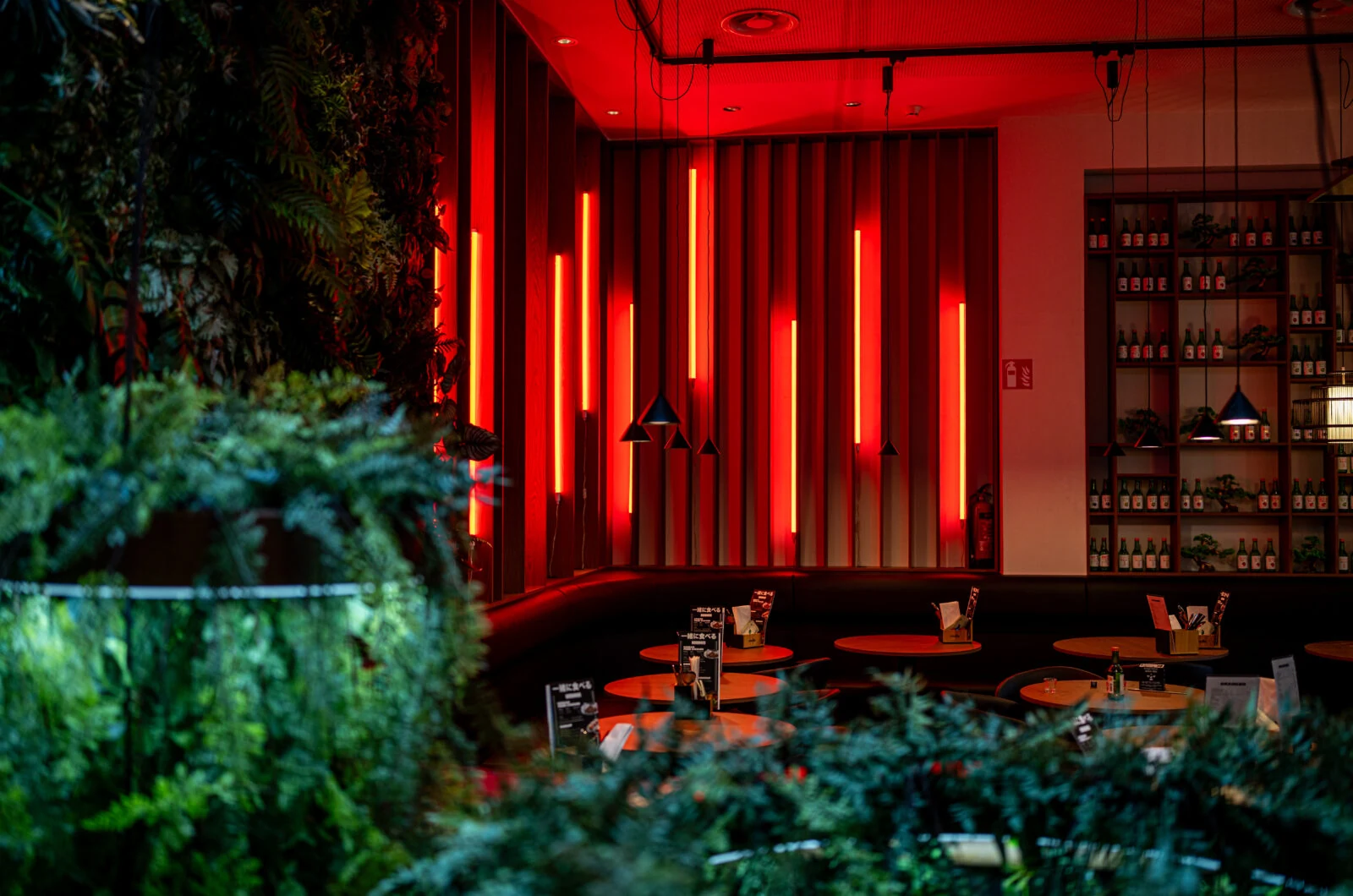Minna Foodclub restaurant interior with red lighting and greenery