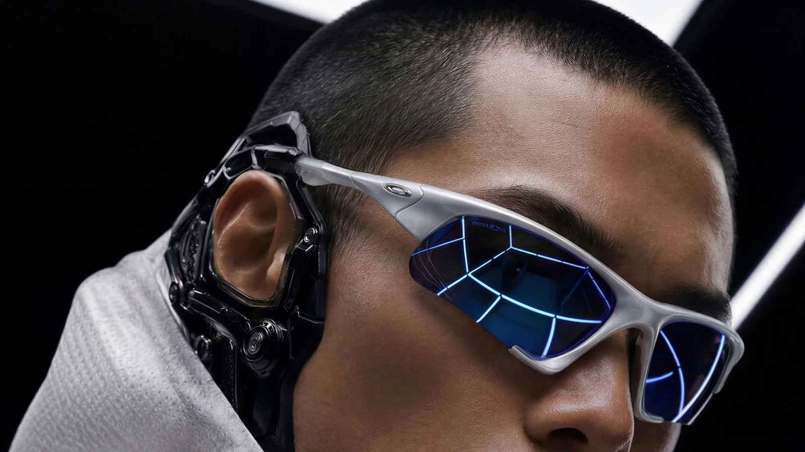 Oakley MUZM Scar and Suture campaign model wearing silver frame eyewear with blue lenses