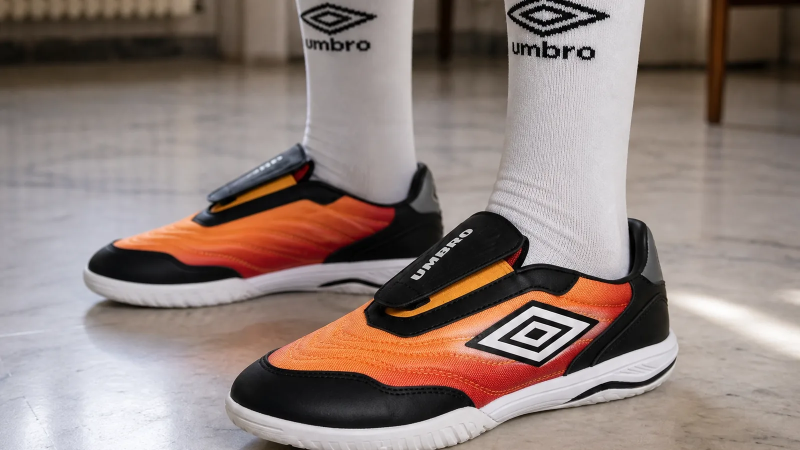 Orange Umbro SS27 footwear with branded socks from the synthetic campaign